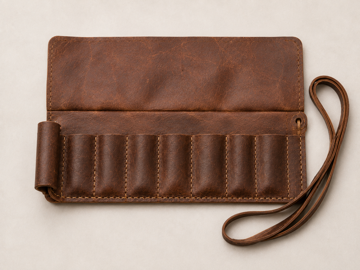 Empty - Old Line Crafts & Designs Empty leather tool roll showing seven graduated pocket bays ridge shaped pocket opening and hardware free wrap strap