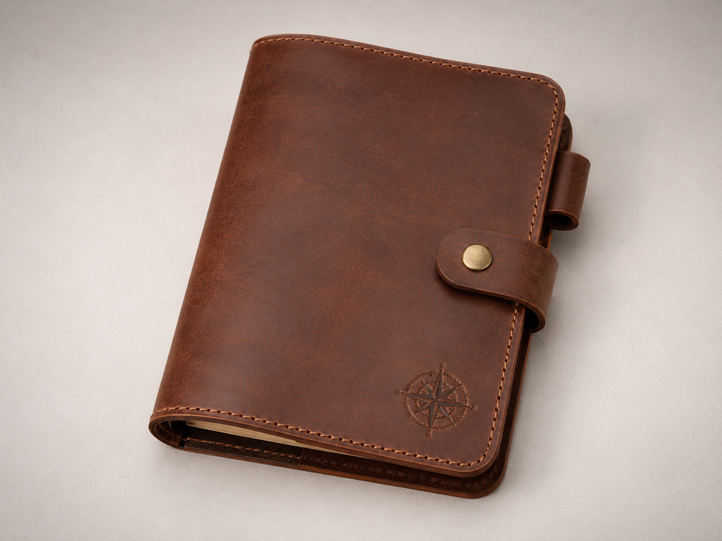 Hero - Old Line Crafts & Designs A handcrafted brown leather A5 journal cover with compass inspired tooling snap closure diagonal inner pocket and pen loop shown in a clean studio product image