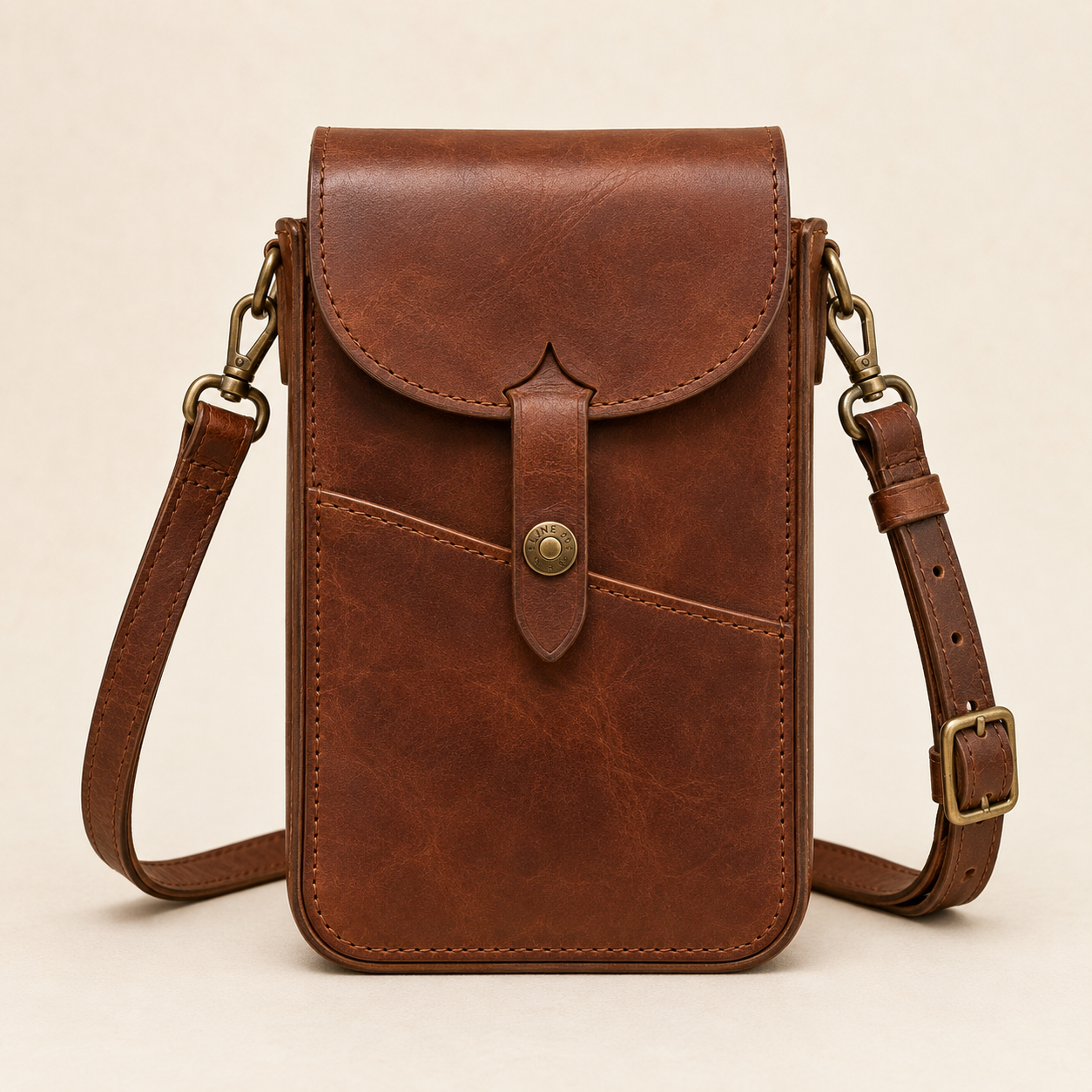 Hero - Old Line Crafts & Designs Chestnut brown leather Waypoint Marketline Crossbody Bag with rounded flap swept front pocket centered snap tab adjustable leather strap and antique brass hardware on a light studio background
